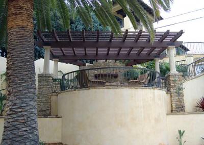 View of living area with pergola, fireplace and retaining walls