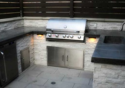 Outdoor kitchen featuring grey concrete counter tops